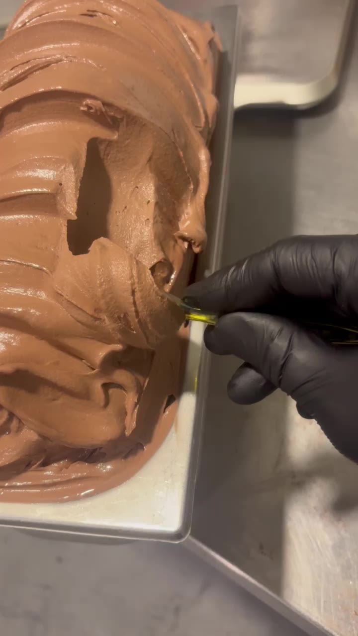 Frisch hergestelltes Schokoladen-Gelato wird in der Manufaktur von La Nocciola in die Eiswanne gestrichen