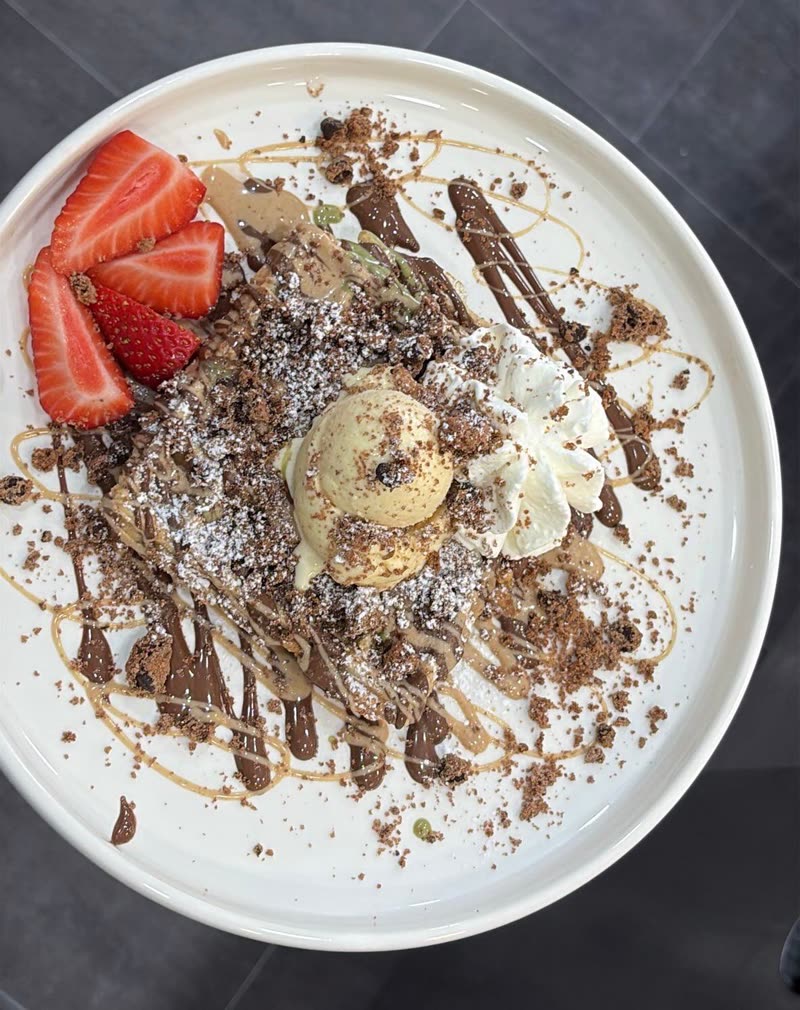 Waffel mit Pistazien- und Haselnusscreme, Schokolade, Sahne und frischen Erdbeeren
